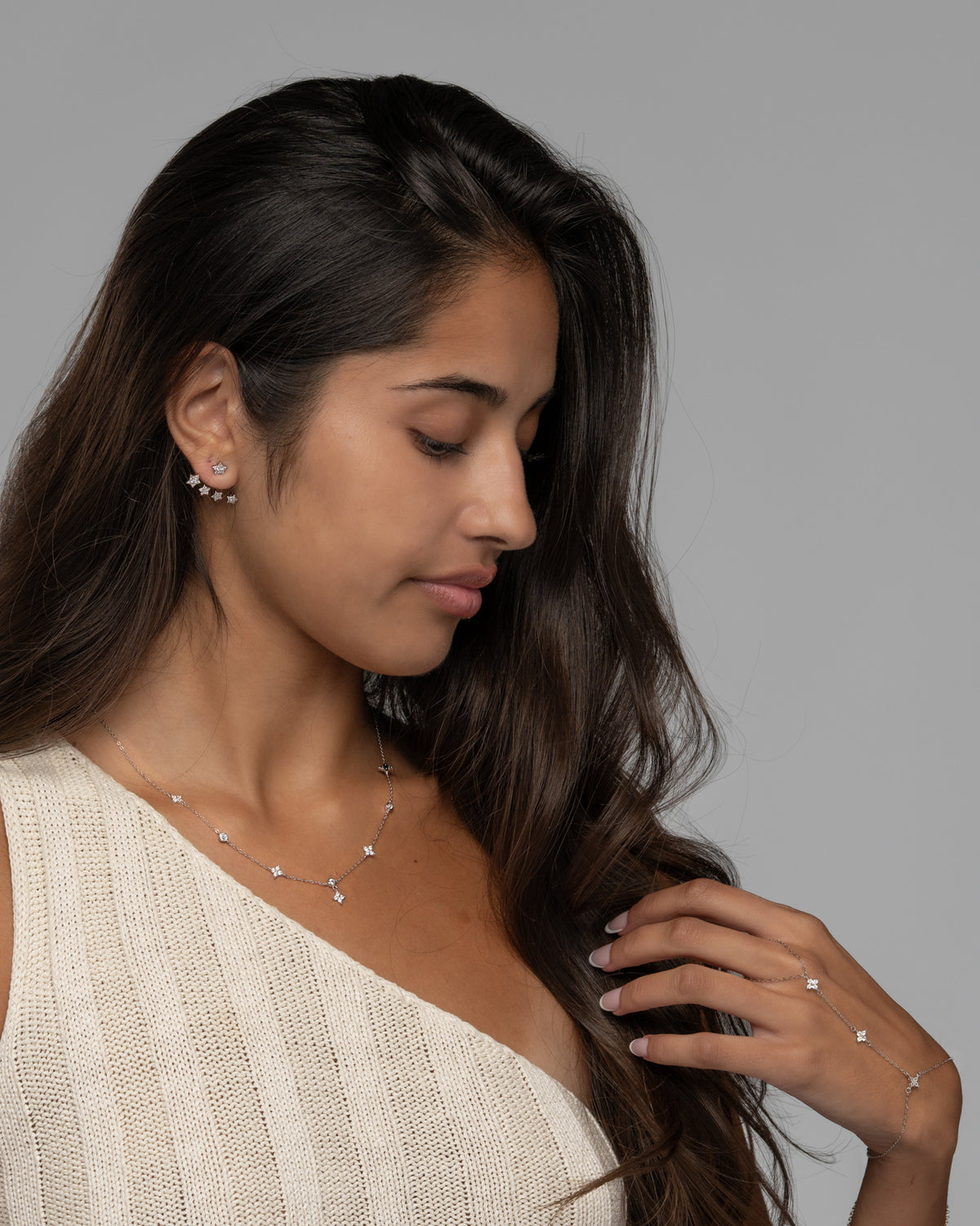 Jia star earrings worn with a delicate star charm necklace