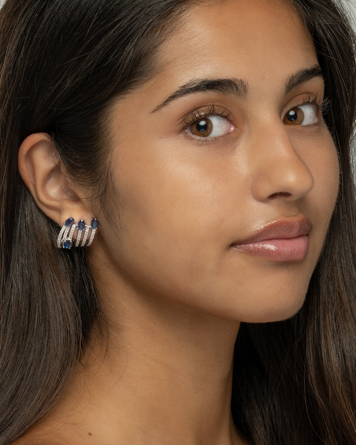 Model wearing the Nia claw earrings, showing the stacked hoop illusion on a single piercing