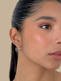 Close up of the Carla claw earrings on the ear with a sleek pulled back hairstyle
