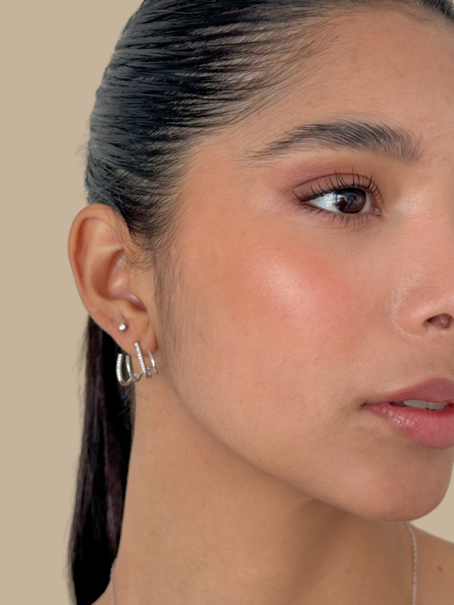 Close up of the Carla claw earrings on the ear with a sleek pulled back hairstyle