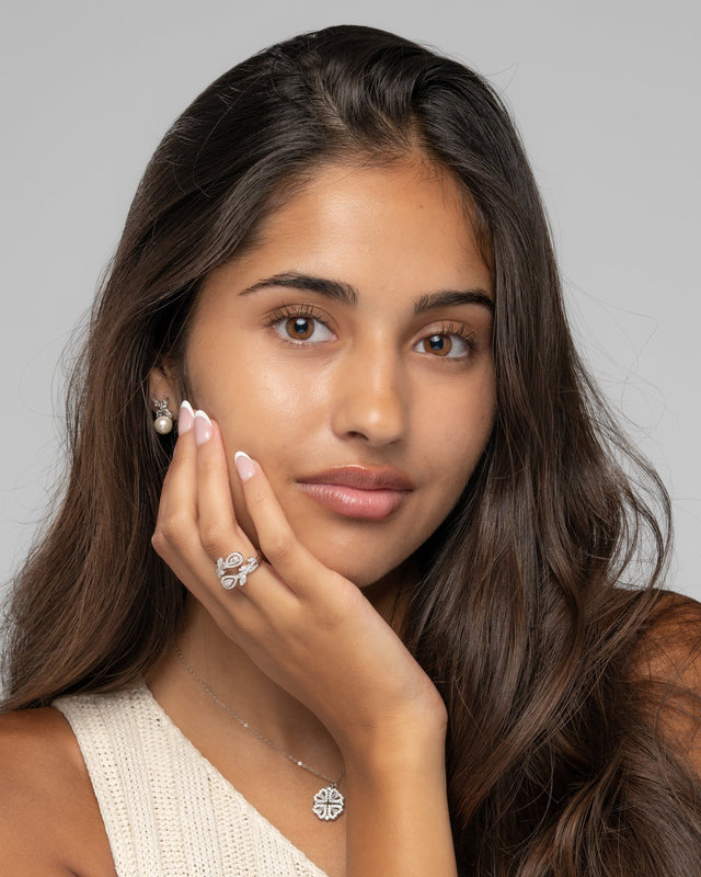 Model wearing the Chloe pearl drop earrings with a cream knit top