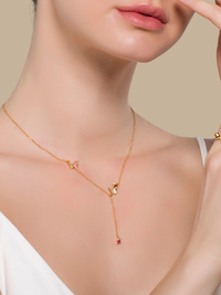 Astrid gold butterfly lariat necklace worn at the collarbone, showing the delicate Y drop against bare skin