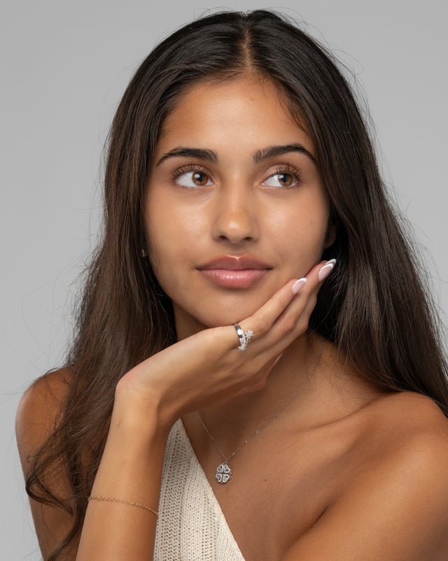 Model wearing the Aya Bliss flower ring, hand resting under the chin