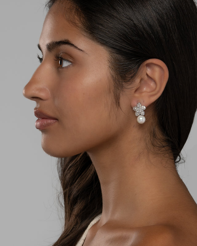 Side view of the Blanca pearl earrings on the ear, showing the pearl sitting just below the flower cluster