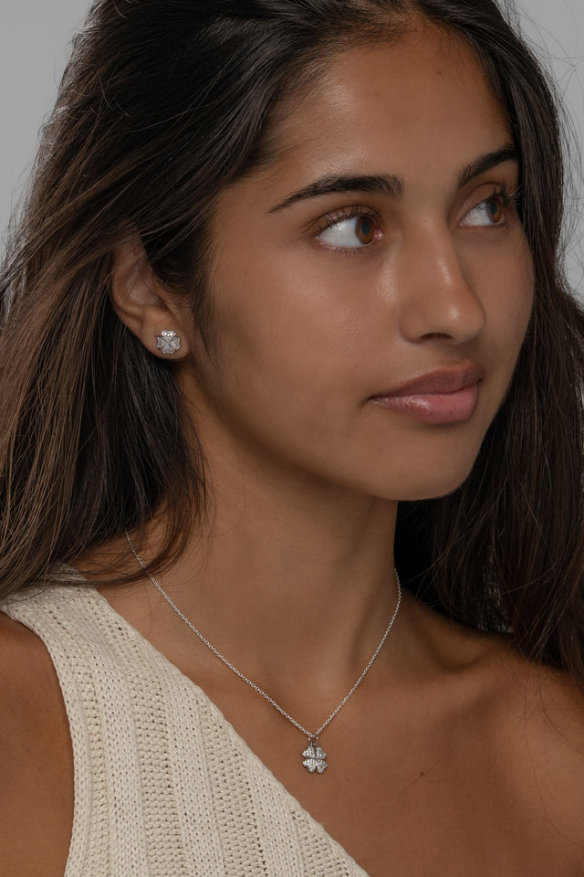 Three quarter view of the Cara clover necklace and studs worn in sterling silver