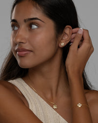 Side view of the Cara clover stud earring and pendant necklace in gold