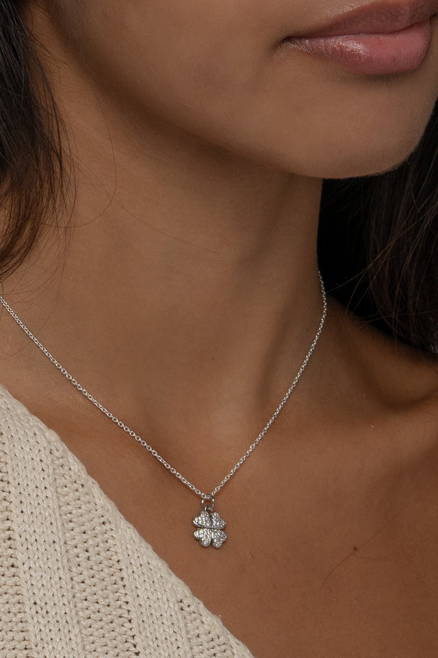 Close up of the Cara clover pendant worn at the collarbone in silver