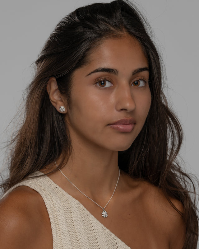 Model wearing the Cara clover necklace set in silver with a cream knit top