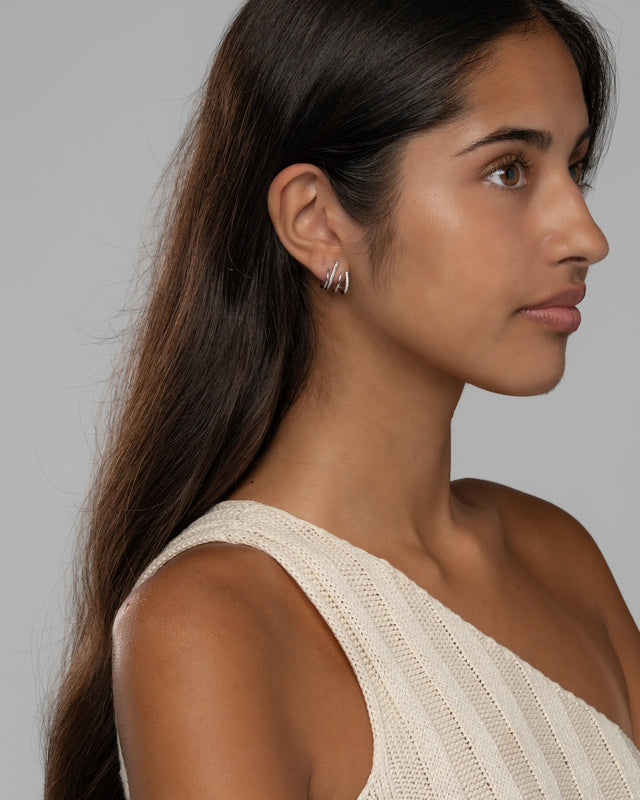 Model wearing the Carla claw earrings, side view showing the stacked hoop effect