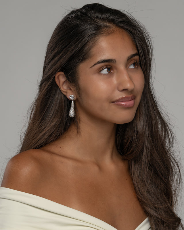 Model wearing the Diorra pave drop earrings, three quarter view