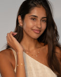Model wearing the Irene star charm bracelet and necklace together in gold