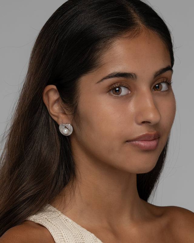 Model wearing the Lusterloop pearl swirl earrings, three quarter view