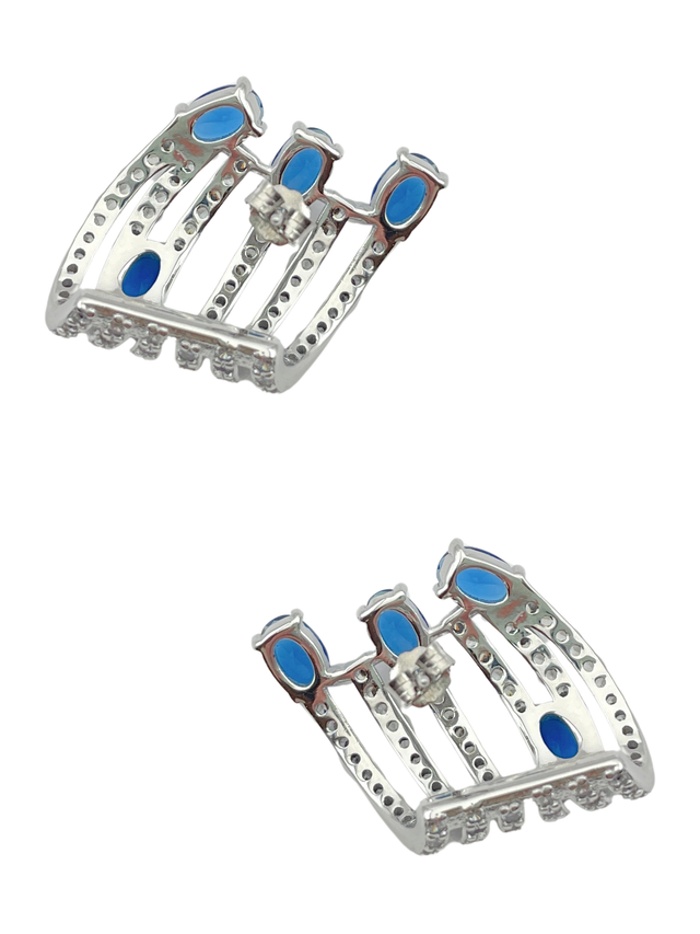 Angled view of the Nia claw earrings showing the blue stones set along sterling silver claw bars