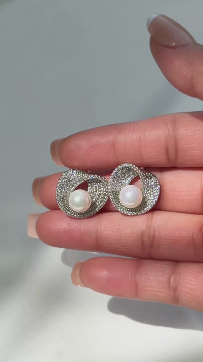 Video of the Lusterloop earrings, pave swirl studs cradling a pearl in silver tone