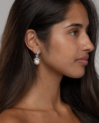 Side view of the Rania pearl earrings on the ear, showing the drop length