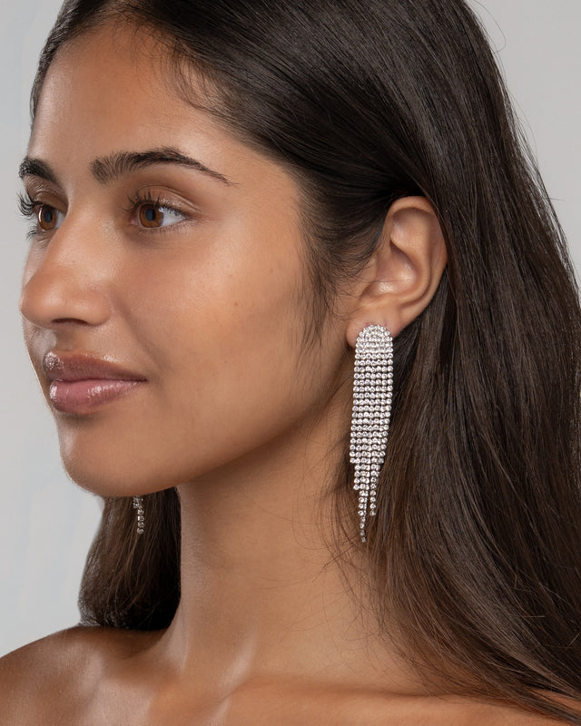 Model wearing the Sally shimmer crystal fringe earrings, side view showing the full length of the drop