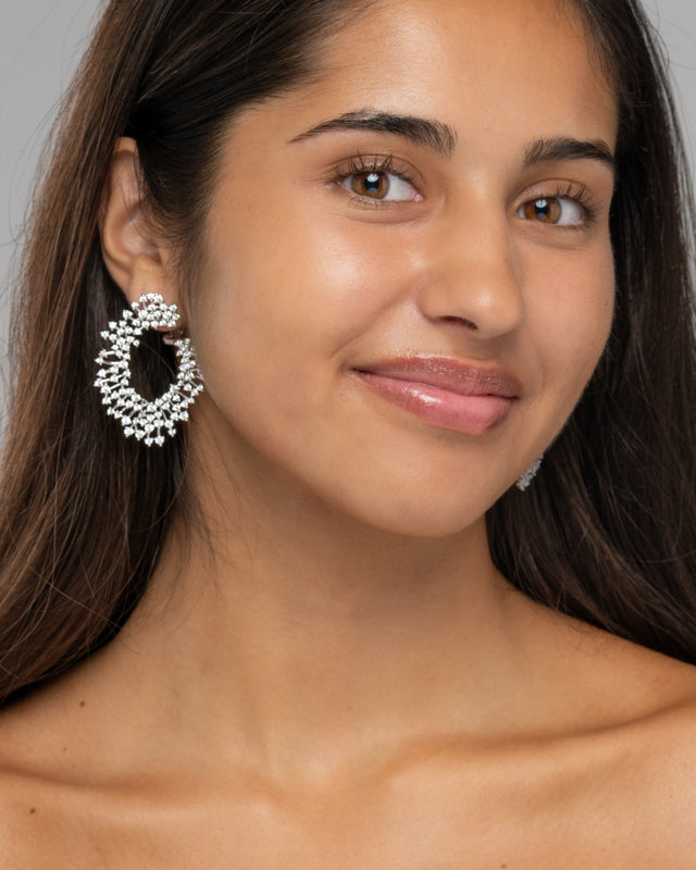 Close up of the Zahra earring on the ear, showing the sculpted open swirl