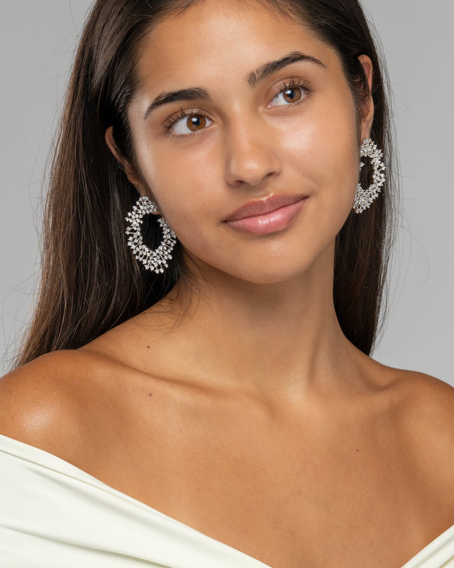 Model wearing the Zahra statement earrings with an off shoulder ivory top